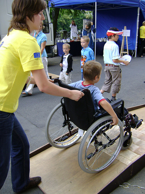 Chico en silla de ruedas participando en una actividad al aire libre
